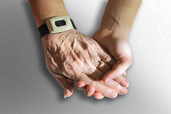 A family member holding the hand of an elderly who is a nursing home abuse victim in Atlanta.