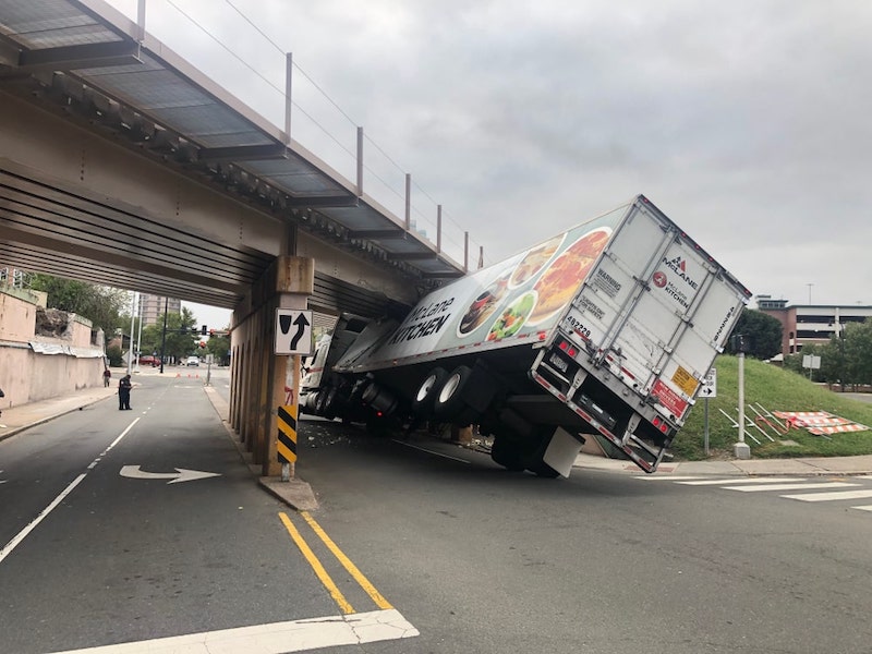 Semi Truck Stuck Behind A Bridge That Is Lower Than The Truck Itself