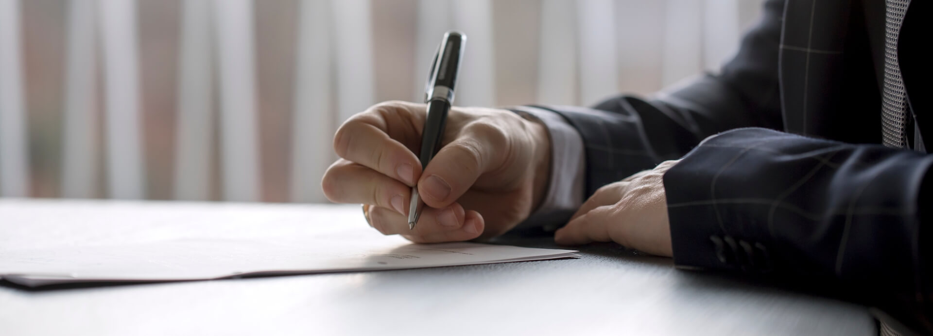 Man signing a document in a law office or at a notary's table