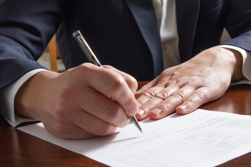 Photo of a man writing on a piece of paper