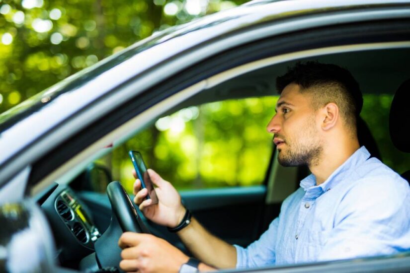 Photo of a man with phone in hand in the car