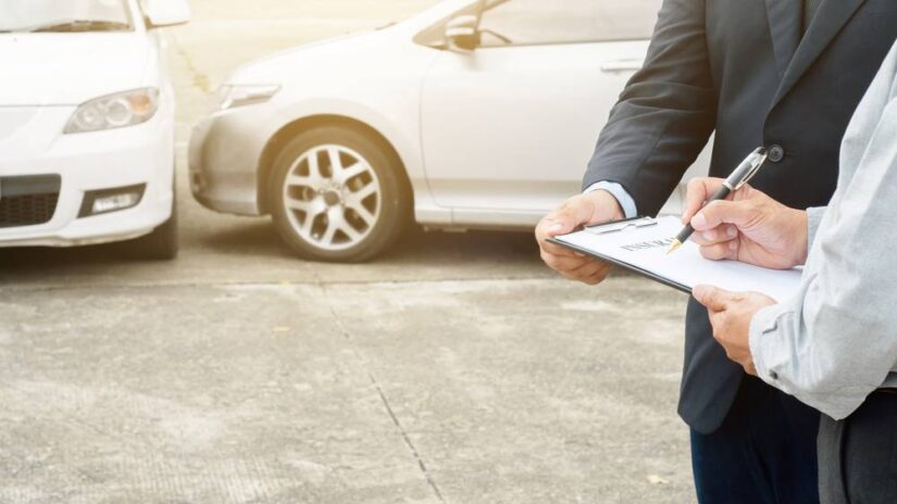 Photo of people next to damaged cars filling papers